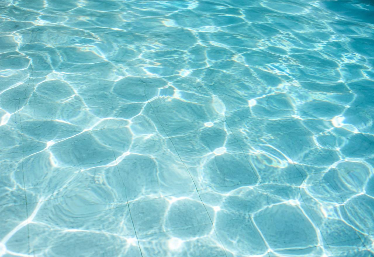 Água cristalina de piscina com reflexos de luz
